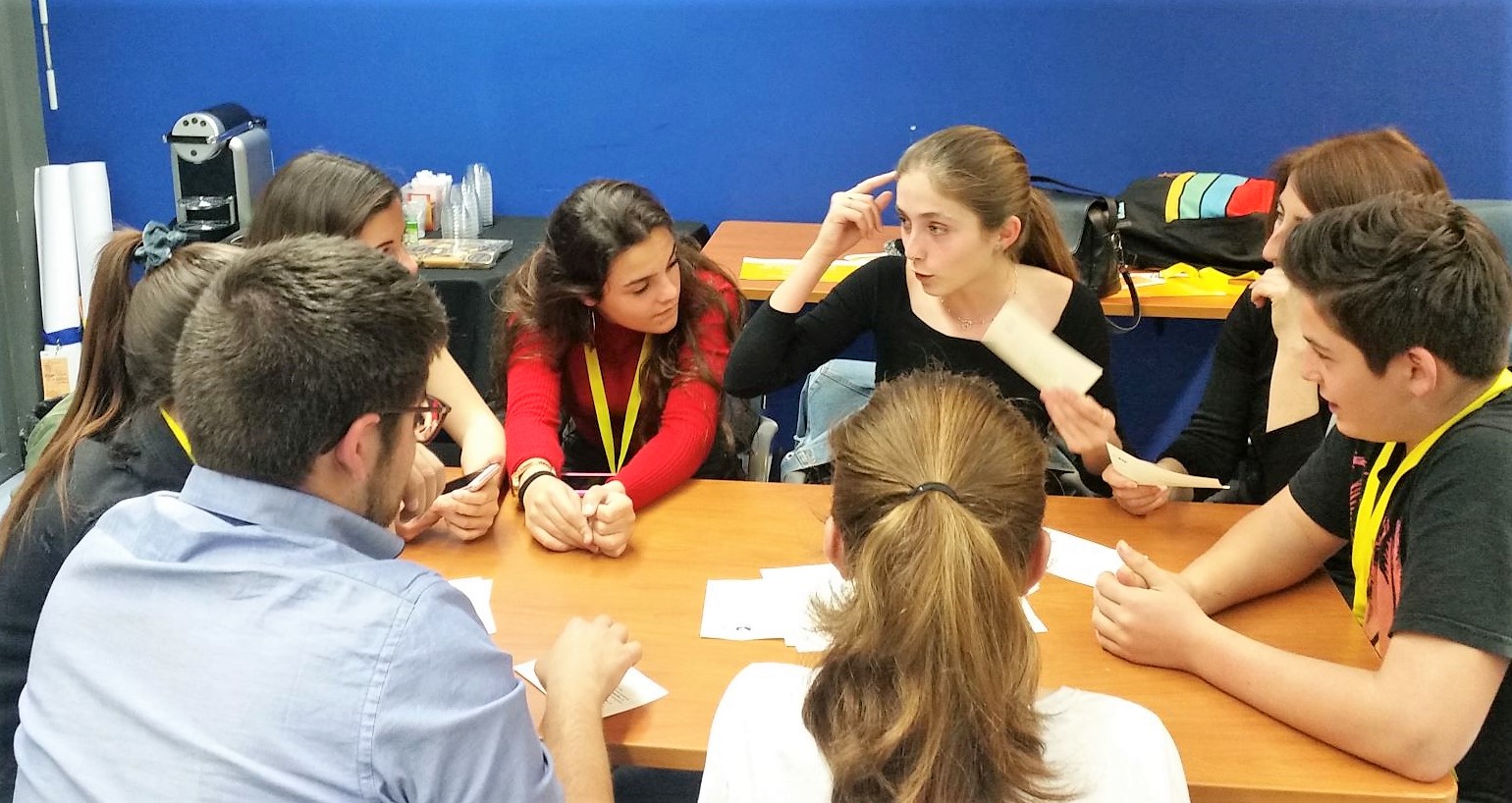 students talking around a table while playing the Decide Game